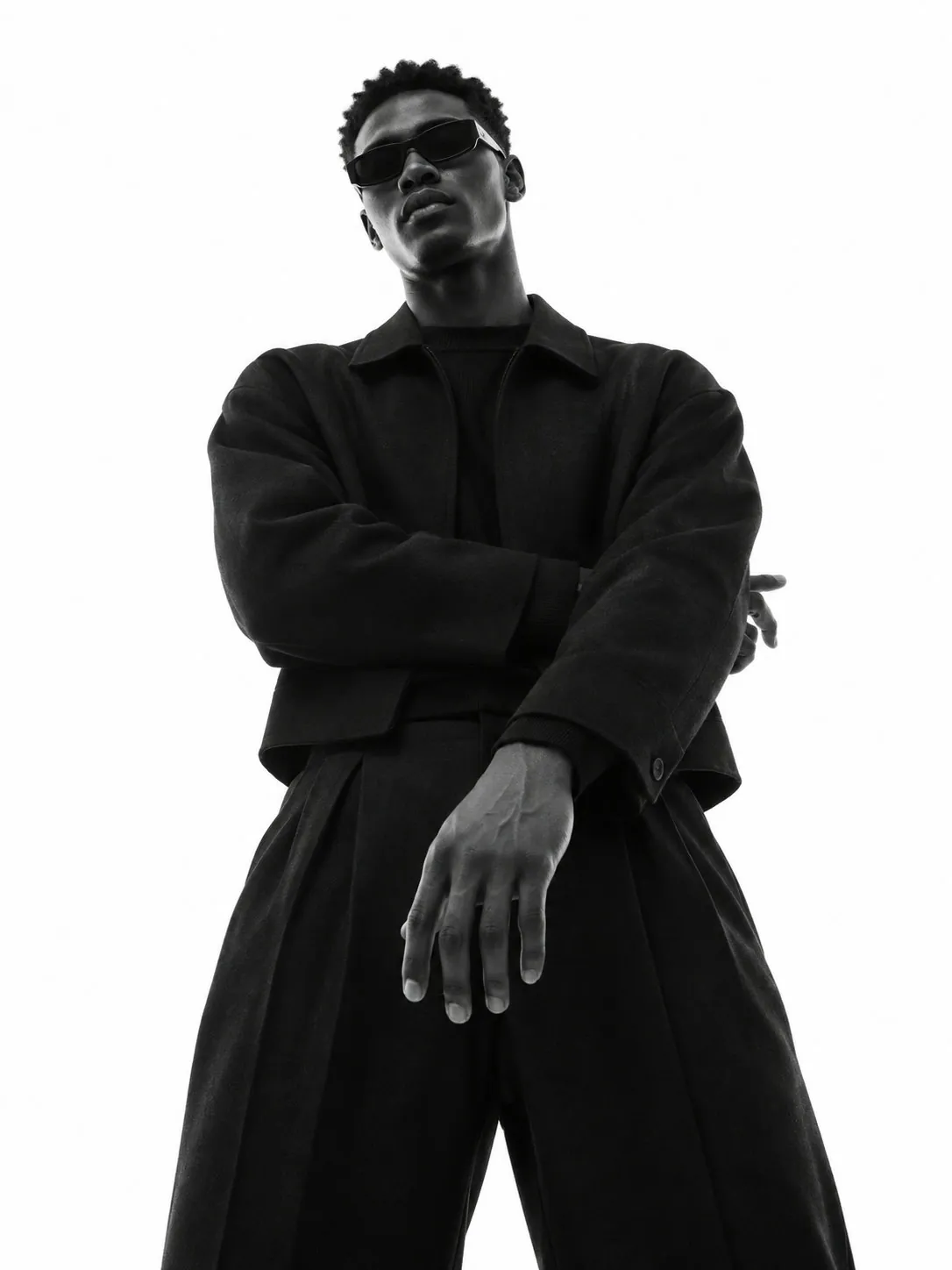 Figura de pie sobre fondo blanco, traje negro