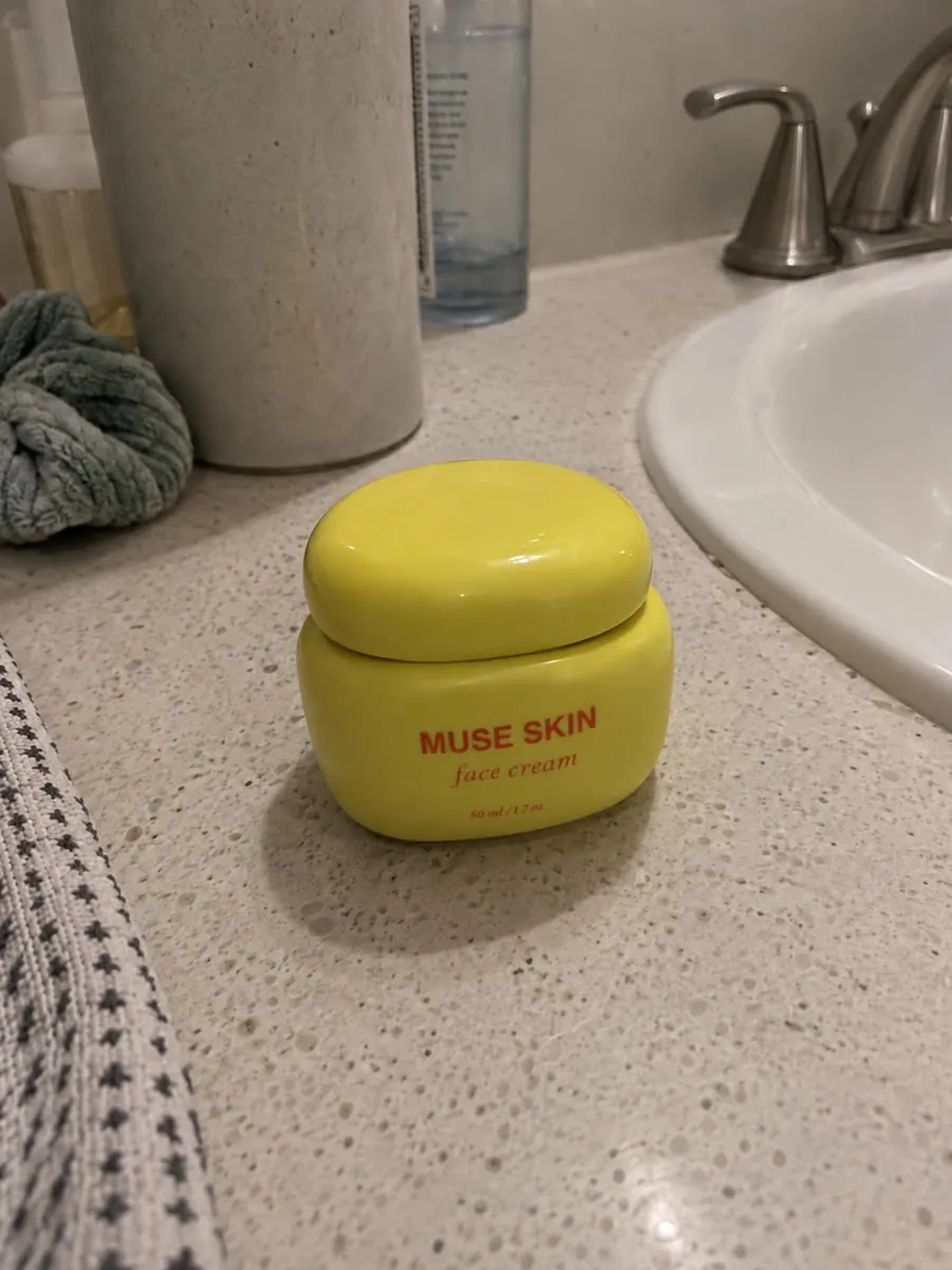 Tarro de crema MUSE SKIN fotografiado con el móvil sobre la encimera del baño